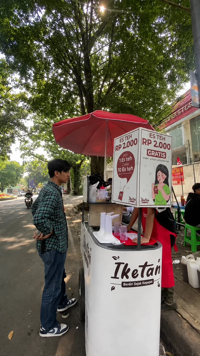 Gerobak Iketan di tepi jalan di bawah pepohonan