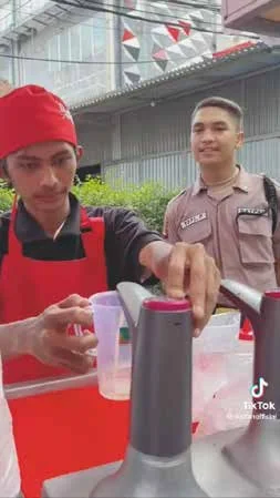 Penjual Iketan menuangkan teh untuk pembeli